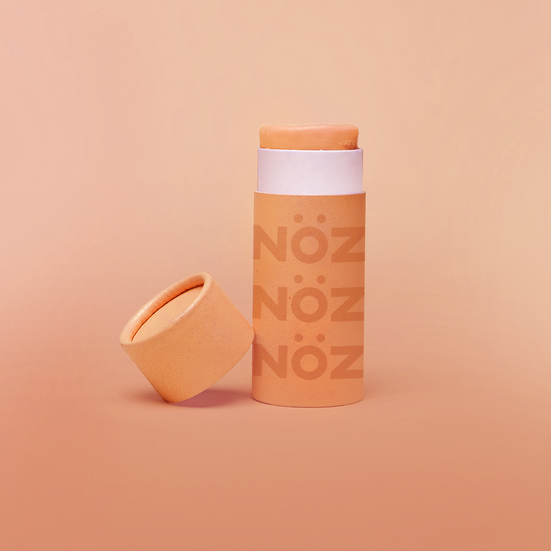 Cap off view of Noz Sunscreen Stick in orange