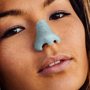 Close up view of a woman's face with Noz Sunscreen Stick in blue